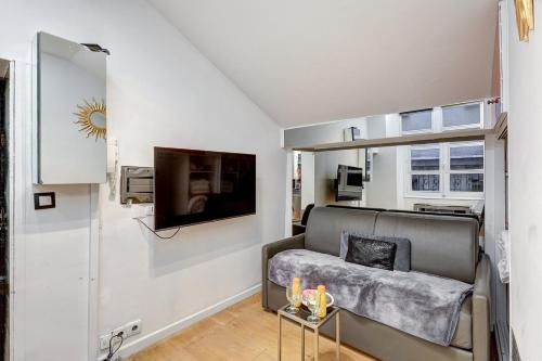 een woonkamer met een bank en een tv bij 668 Suite Sarah - Superb Apartment in Paris in Parijs