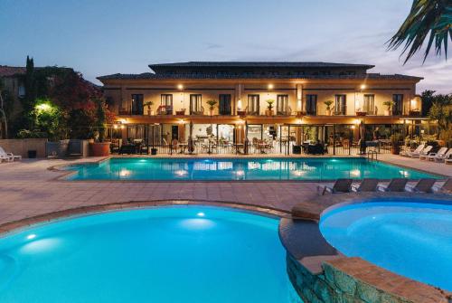 une grande piscine en face d'une maison dans l'établissement Hôtel et Résidence Benista, à Monticello