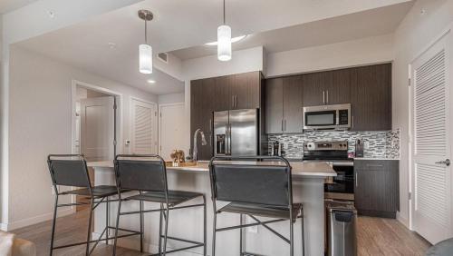 uma cozinha com uma mesa com cadeiras e um frigorífico em Landing Modern Apartment with Amazing Amenities (ID8083X55) em Fort Myers Villas