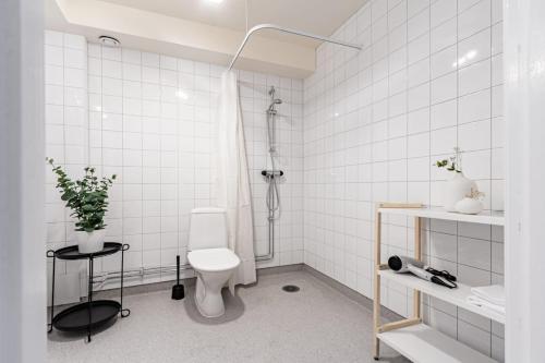 a white bathroom with a toilet and a shower at Modern Charm Stylish Studio in Sodermalm in Stockholm