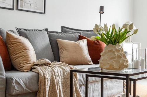 a living room with a couch with pillows and a table at Cheap stay on hip Södermalm - construction work in Stockholm