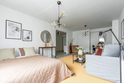 a bedroom with a bed and a living room at Modern Charm Stylish Studio in Sodermalm in Stockholm