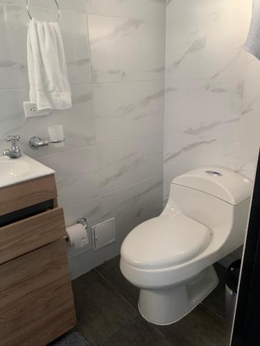 a bathroom with a white toilet and a sink at Hermosa Casa Central - Rositas's house in La Mesa