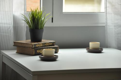 duas xícaras numa mesa com livros e uma planta em vasos em La Casa Verde - Ruzafa em Valência