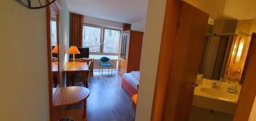 a room with a bathroom with a sink and a desk at Flörsheimer Hof in Flörsheim