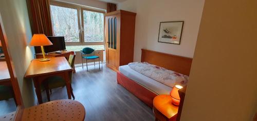 Schlafzimmer mit einem Bett und einem Schreibtisch mit einem Computer in der Unterkunft Flörsheimer Hof in Flörsheim