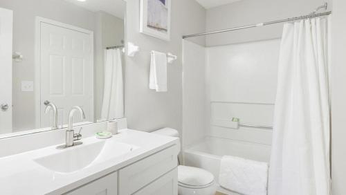 uma casa de banho branca com um lavatório, um WC e uma banheira em Landing Modern Apartment with Amazing Amenities (ID1263X661) em New Albany