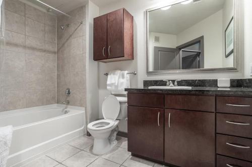 y baño con aseo, bañera y lavamanos. en Landing Modern Apartment with Amazing Amenities (ID1649X92) en Houston