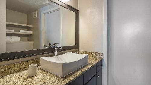 ein Badezimmer mit einem Waschbecken und einem großen Spiegel in der Unterkunft Landing Modern Apartment with Amazing Amenities (ID4179X58) in Austin