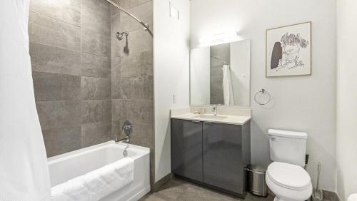 a bathroom with a tub and a toilet and a sink at Landing Modern Apartment with Amazing Amenities (ID8398X77) in Chicago