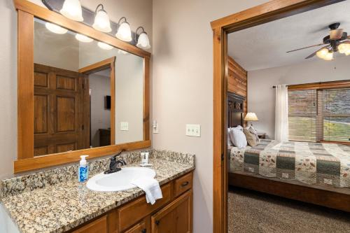 uma casa de banho com um lavatório, um espelho e uma cama em Deer Valley em Branson