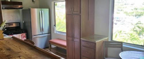 a kitchen with a refrigerator and a window at Tillett Gardens Guest House & Hostel in Nazareth