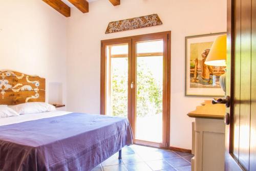 - une chambre avec un lit et une porte coulissante en verre dans l'établissement Villa Zaffiro, à Pollina