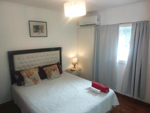 un dormitorio con una cama con un animal de peluche rojo en Barrio Norte hermoso apart privado en San Miguel de Tucumán