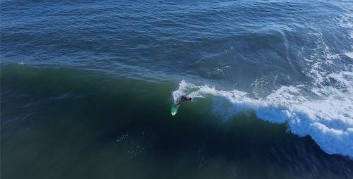 エル・クコにあるSugarloaf Beach House & Surf Lodgeの波に乗る者