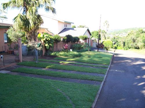 a yard with a house and a driveway at Birdcage B&B in Amanzimtoti