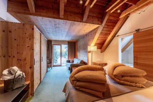 - une chambre avec un lit dans une pièce dotée de plafonds en bois dans l'établissement Hotel Restaurant Seehaus Mountain Lake Resort, à San Giuseppe in Anterselva