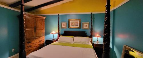 a bedroom with a four poster bed and two lamps at Tillett Gardens Guest House & Hostel in St Thomas