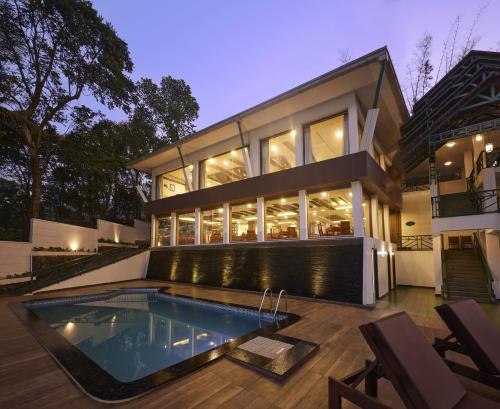 a house with a swimming pool in front of it at Forest Canopy Thekkady in Thekkady
