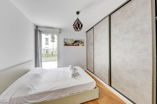 een slaapkamer met een wit bed en een grote muur bij Chic Appart Terrasse Zen & Parking in Gentilly