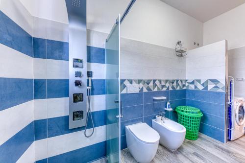 a blue and white bathroom with a toilet and a shower at Casa Sofia in Torre Pali 