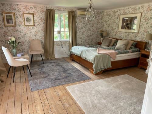 een slaapkamer met een bed, een tafel en een stoel bij Bagarstugan in Kolbäck