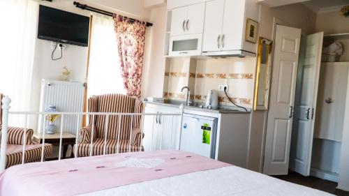 uma pequena cozinha com um lavatório e um frigorífico em Ede Apart Otel em Geyikli