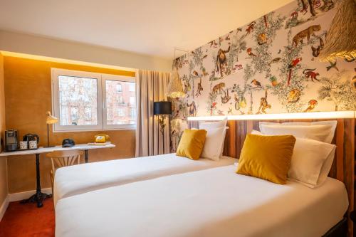 a hotel room with two beds with yellow pillows at Kopster Hotel Paris Porte de Versailles in Paris