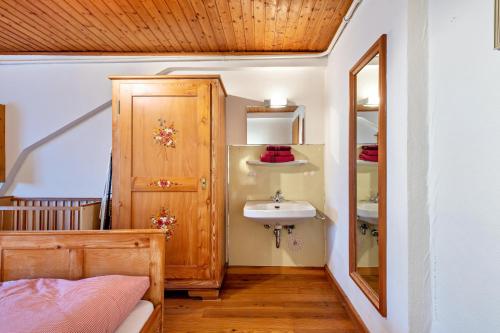 uma casa de banho com um lavatório e uma porta de madeira em Ferienwohnung Hofidylle em Münstertal