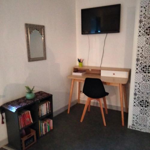 a room with a desk and a television on a wall at le jack in Mont-sous-Vaudrey