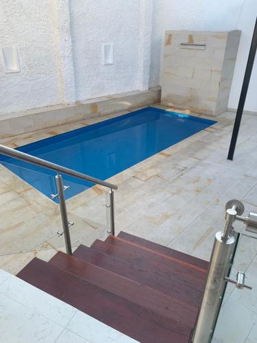 a swimming pool in a room with a staircase at Hermosa Casa Central - Rositas's house in La Mesa