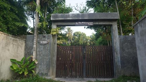 a gate with a wooden fence and a gate with a gate sidxhaarhaarhaar at The Whitegates Lodge in Weligama