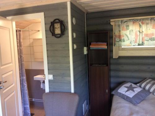 ein kleines Zimmer mit einem Bett und einer Uhr an der Wand in der Unterkunft Mäkelän Lomatuvat Cottages in Korkeakoski