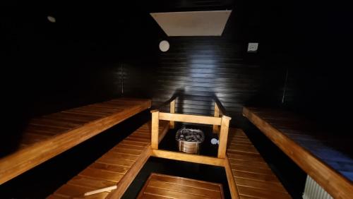 a room with two wooden benches and a bucket at Vanha-Merivartioasema in Kotka