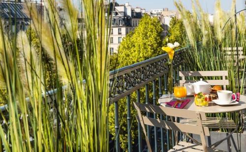 einen Tisch und Stühle auf einem Balkon mit Aussicht in der Unterkunft Chambre avec terrasse à Montmartre Sacré Coeur in Paris