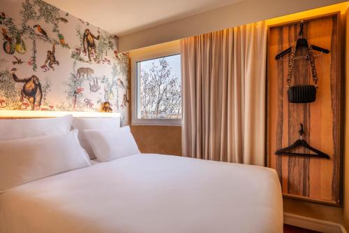 a bedroom with a white bed and a window at Kopster Hotel Paris Porte de Versailles in Paris