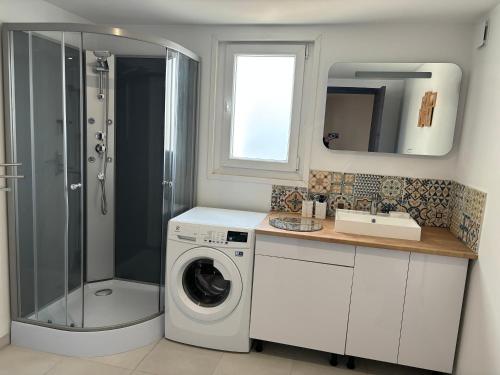 uma casa de banho com uma máquina de lavar roupa e um lavatório em Grande maison 6-8 couchages em Auchy-les-Mines