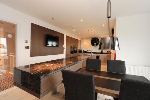 a kitchen with a dining room table with chairs at Viewpoint Villa - Luxury 4 Bedroom villa with elevated views in Rothesay