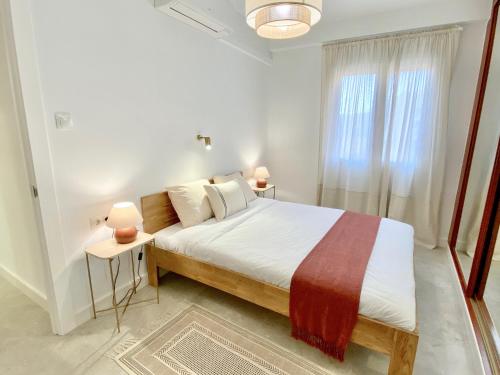 a bedroom with a bed and two lamps and a window at Amplio apartamento en el centro de Málaga in Málaga