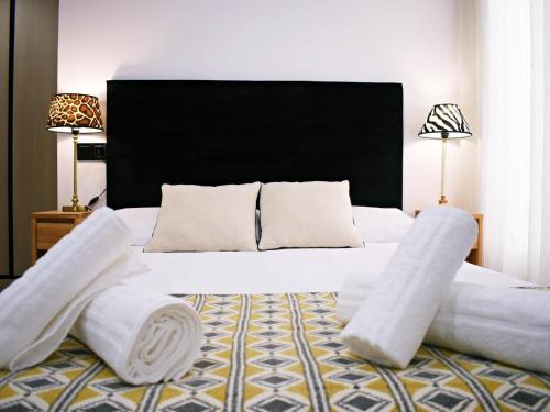 a bedroom with a large white bed with towels on it at Espléndido estudio en el Centro Histórico de Málaga. in Málaga