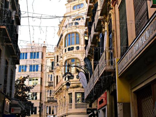 a tall building with lots of windows on a street at Espléndido estudio en el Centro Histórico de Málaga. in Málaga