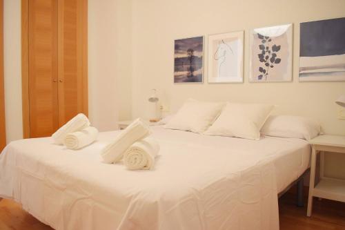 a white bed with white towels on top of it at Coqueto Apartamento Cerca del Centro Histórico in Málaga
