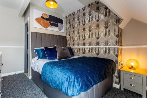 a bedroom with a bed with a blue comforter at Room 07 - Sandhaven Rooms Double in South Shields