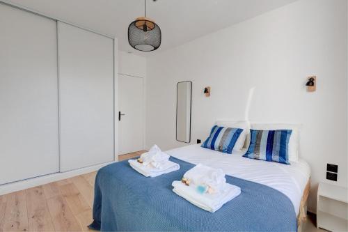 - une chambre blanche avec 2 serviettes sur un lit dans l'établissement 341 Suite Modern Art - Superb Apartment in Paris, à Suresnes
