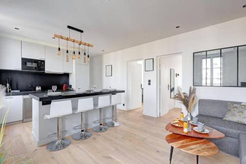 Il dispose d'une cuisine et d'un salon avec un canapé et une table. dans l'établissement 341 Suite Modern Art - Superb Apartment in Paris, à Suresnes