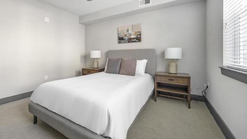 ein weißes Schlafzimmer mit einem großen Bett und zwei Nachttischen in der Unterkunft Landing - Modern Apartment with Amazing Amenities (ID6298X53) in Parker