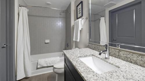 ein Badezimmer mit einem Waschbecken, einer Badewanne und einem WC in der Unterkunft Landing - Modern Apartment with Amazing Amenities (ID6298X53) in Parker