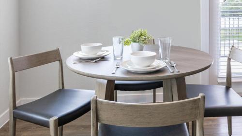 una mesa de madera con 2 sillas y una mesa con tazas y platos en Landing Modern Apartment with Amazing Amenities (ID1348X713), en Chicago