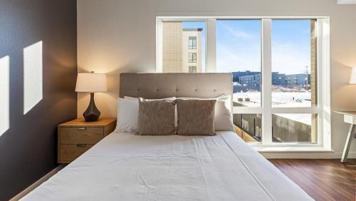ein Schlafzimmer mit einem Bett und einem großen Fenster in der Unterkunft Landing Modern Apartment with Amazing Amenities (ID7082X14) in Portland