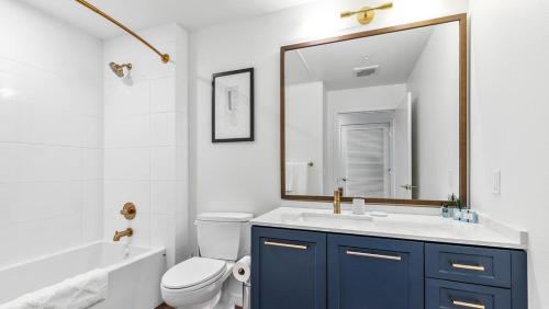 ein Badezimmer mit einem Waschbecken, einem WC und einem Spiegel in der Unterkunft Landing Modern Apartment with Amazing Amenities (ID7082X14) in Portland